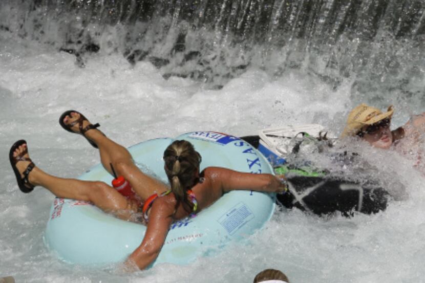 Tubers hang on to their drinks and cooler after getting past a small drop-off in the Comal...