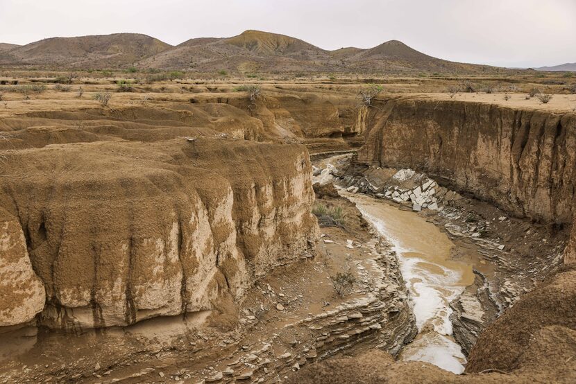 An "arroyo" forms under a heavy rainfall near Chispa Road in Culberson County on June 24,...