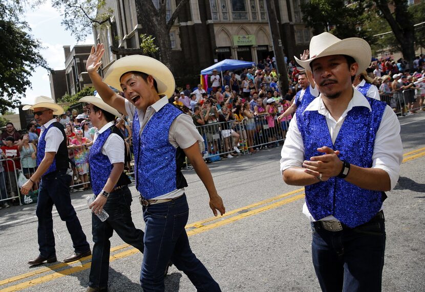 A group of dancing cowboys wave to crowd during the Alan Ross Texas Freedom Parade on Cedar...