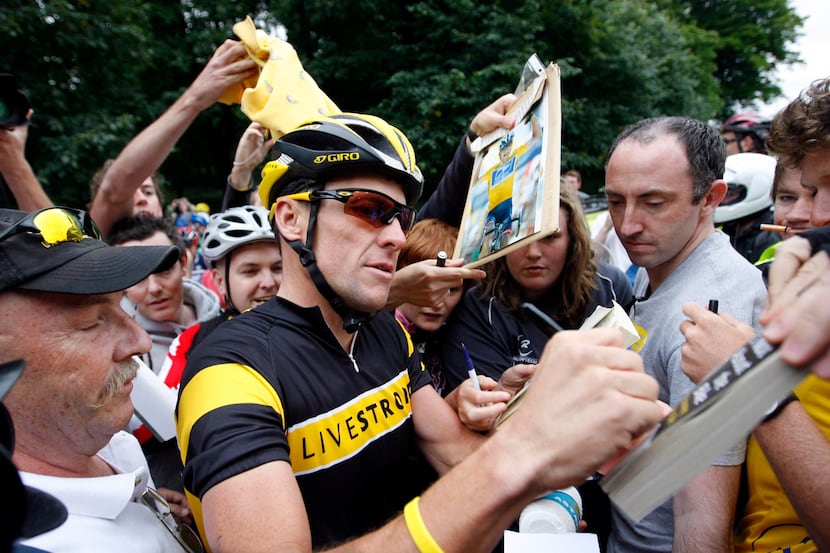 FILE - In this Aug. 25, 2009, file phot, cyclist Lance Armstrong signs autographs as he...
