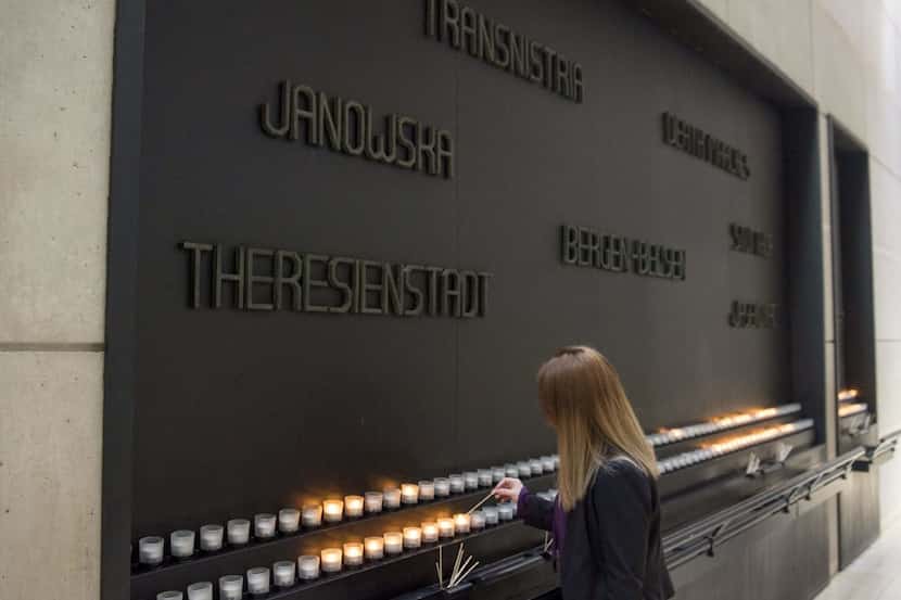 A woman lights a Memorial Candle during an International Holocaust Remembrance Day...
