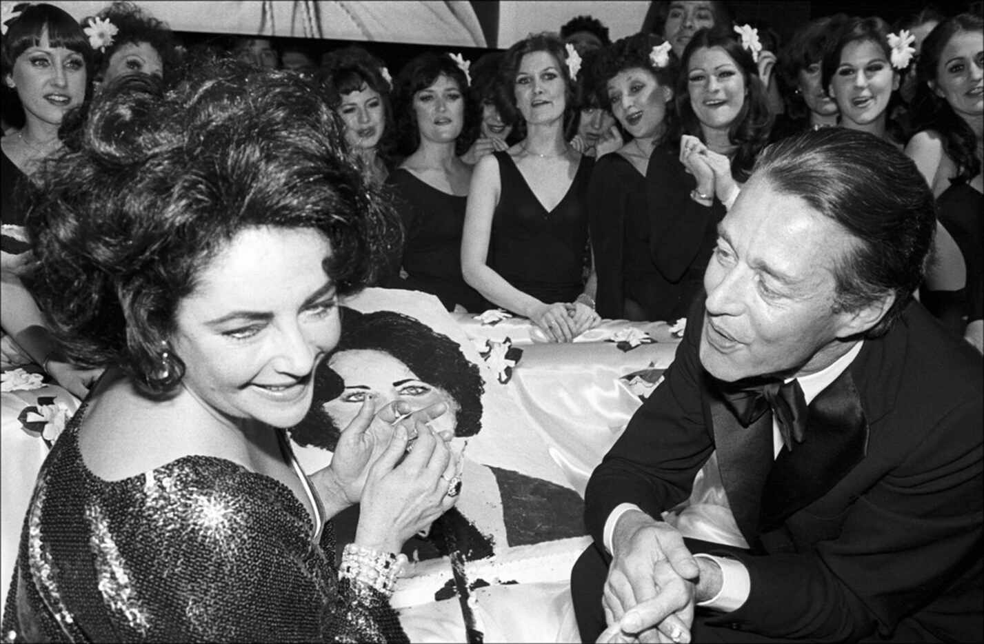Halston, the fashion designer, with Elizabeth Taylor and the Rockettes at her birthday party...