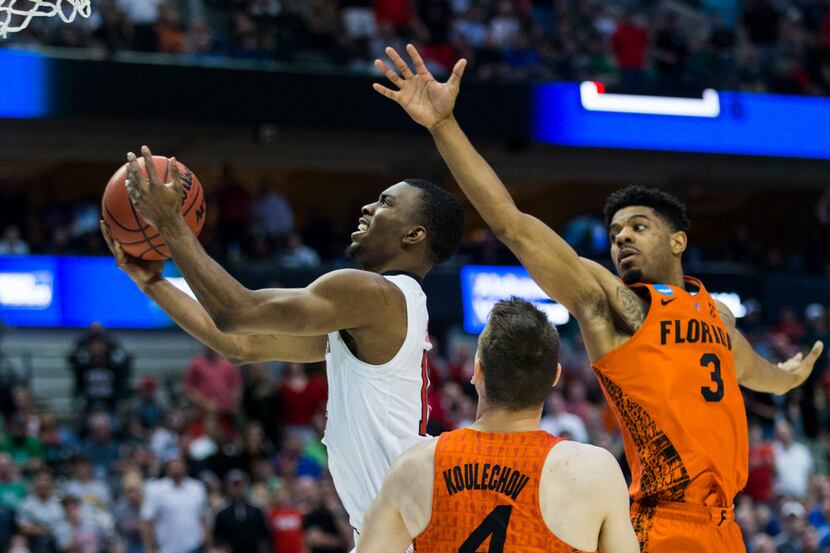Texas Tech's Keenan Evans (12) goes up for a shot ahead of Florida's Jalen Hudson (3) and...