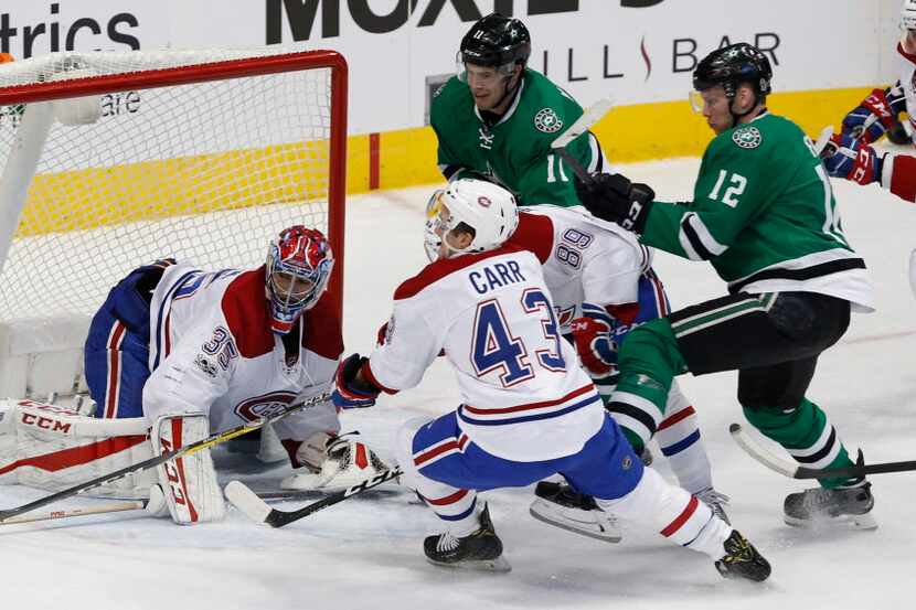 Montreal Canadiens goalie Al Montoya (35) and left wing Daniel Carr (43) fend off a shot...