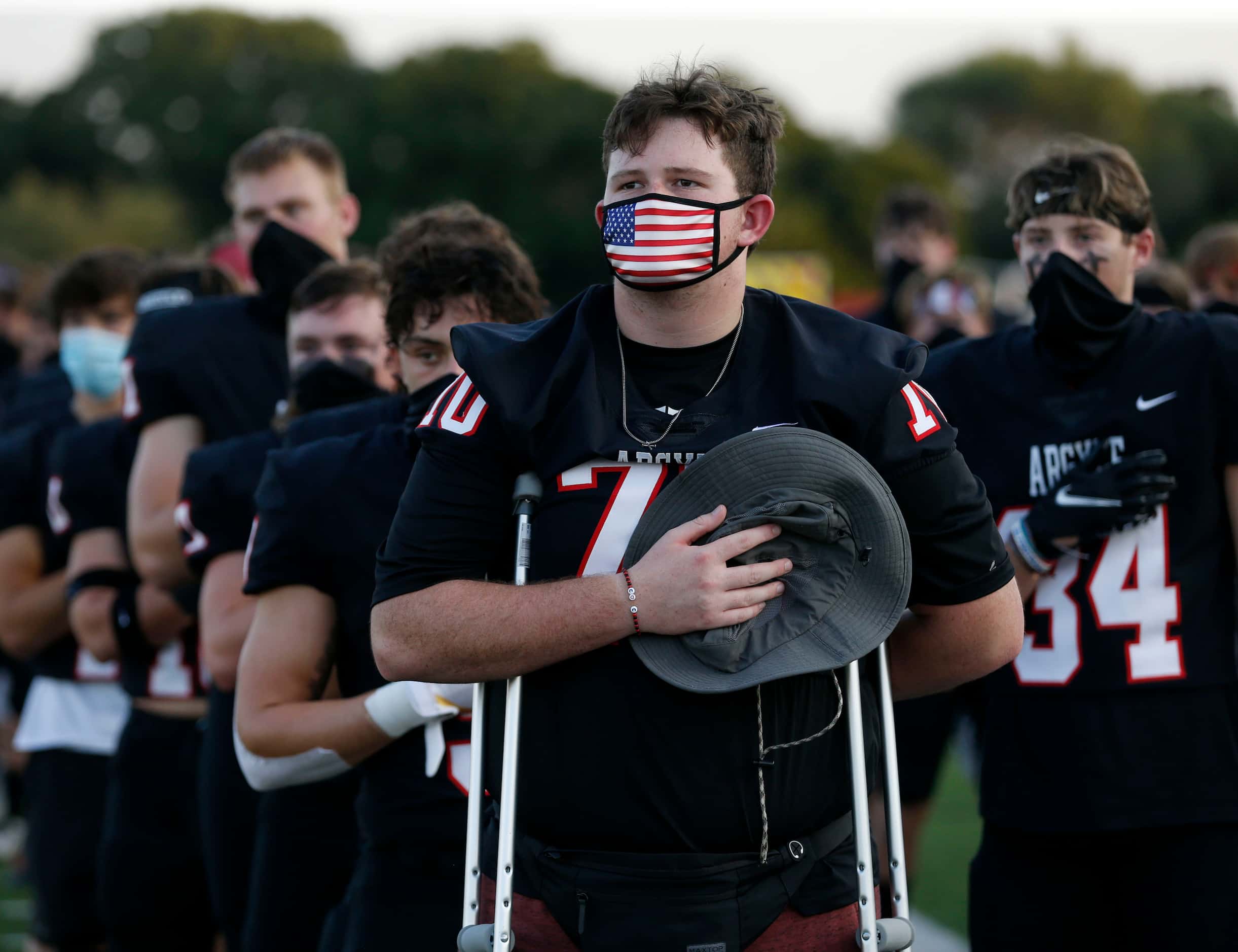 Argyle's Caden Reeves (70) and teammates take part in the National Anthem during a high...