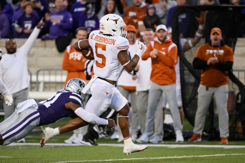Texas running back Bijan Robinson (5) breaks a tackle attempt by Kansas State safety Drake...