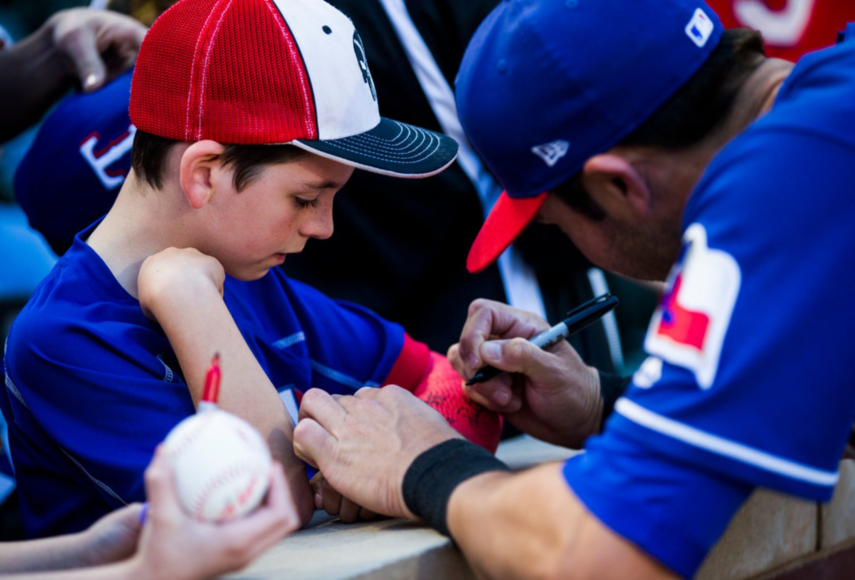 Texas Rangers infielder Chase d'Arnaud (6) signs the cast of Luke Hair, 9, of Burleson,...