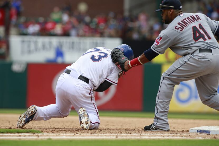 Cleveland Indians first baseman Carlos Santana (41) tags out Texas Rangers second baseman...
