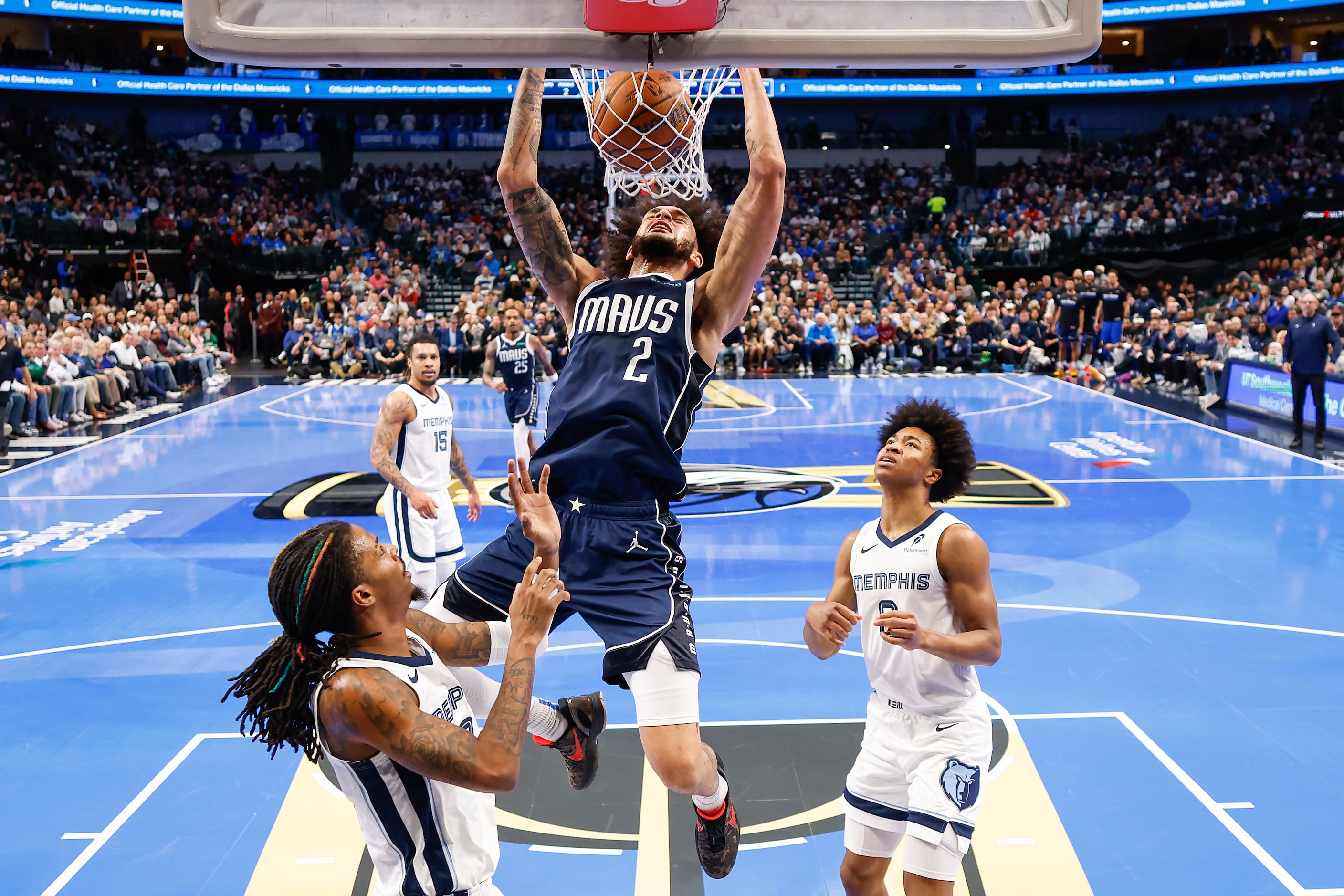 Dallas Mavericks center Dereck Lively II (2) dunks past Memphis Grizzlies guard Ja Morant...