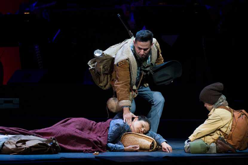 Juan Mejia in the role of Victor, a coyote, touches the face of the dying Renata, portrayed...