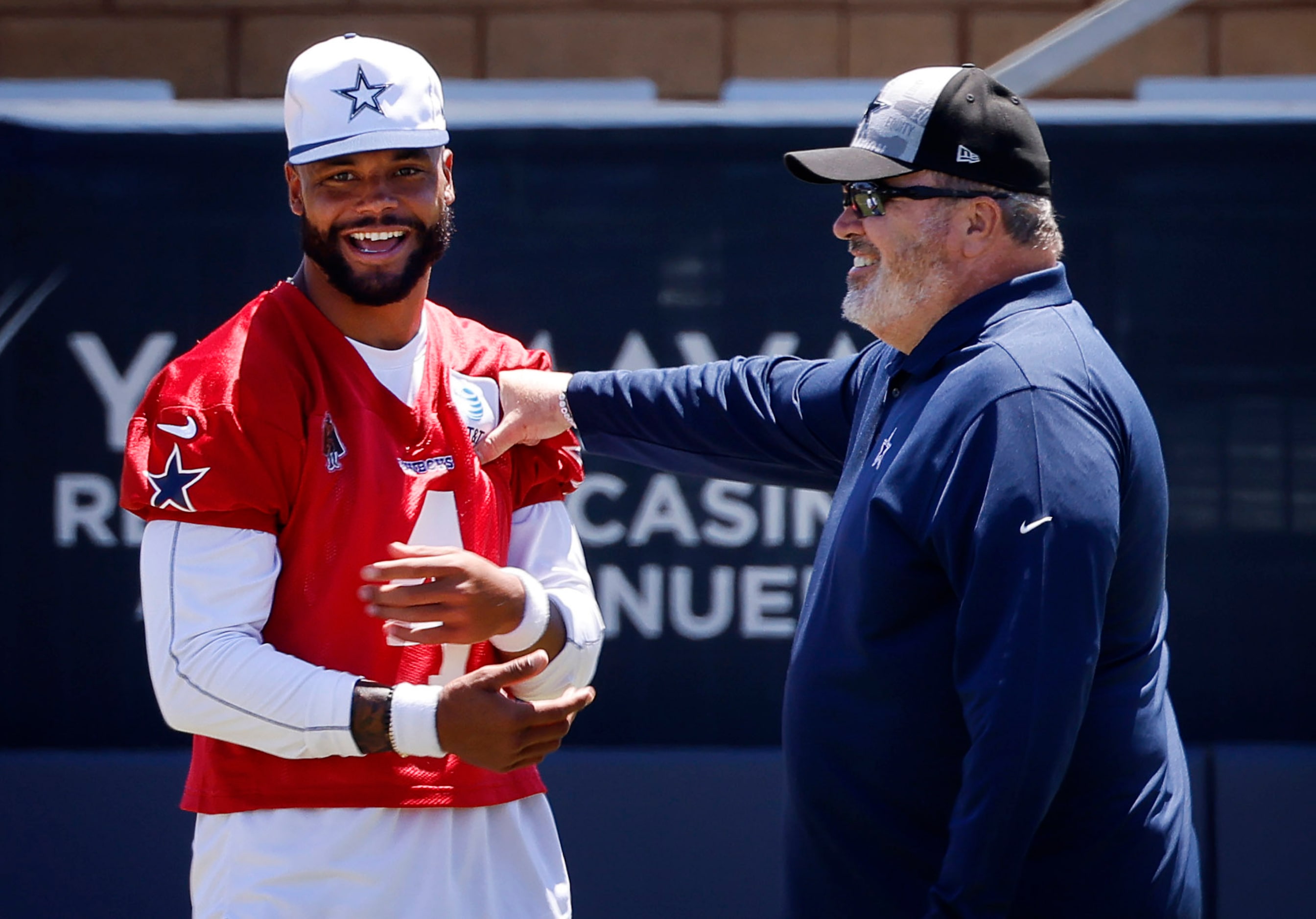 Dallas Cowboys head coach Mike McCarthy  playfully punches quarterback Dak Prescott (4)...