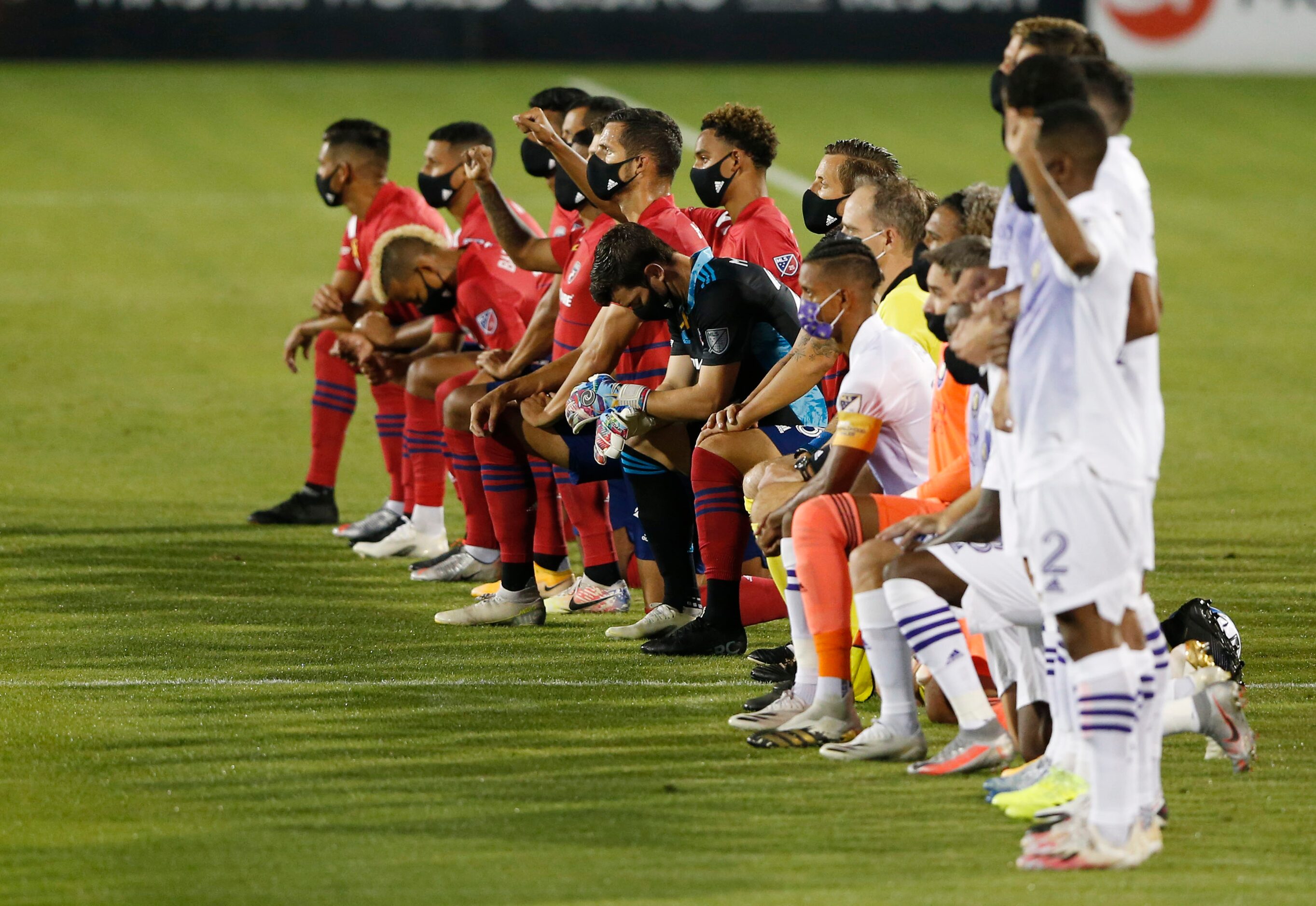 Players from FC Dallas and Orlando City in the middle of the field as the national anthem is...