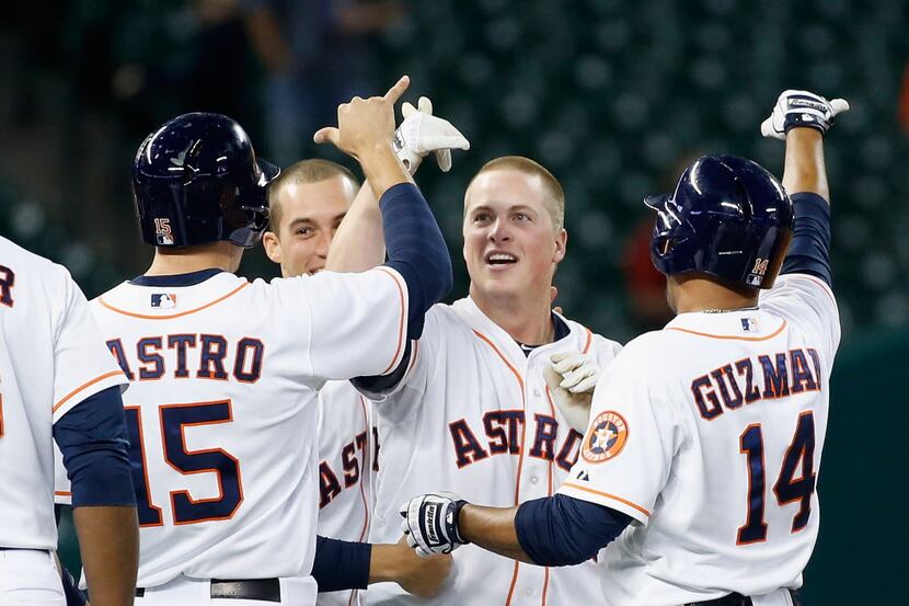 Matt Dominguez #30 (C)  of the Houston Astros celebrates with his teammates after he drove...