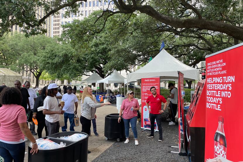 People gather at a recycling event for Coca-Cola Southwest Beverages in downtown Dallas park...