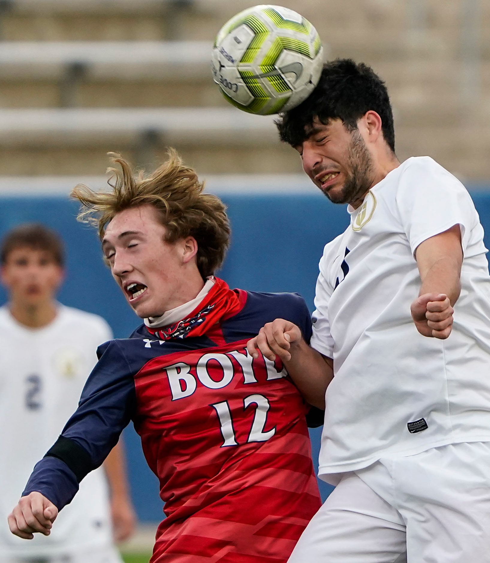 Jesuit midfielder Benton Bacile (21) wins a header against McKinney Boyd midfielder Ethan...