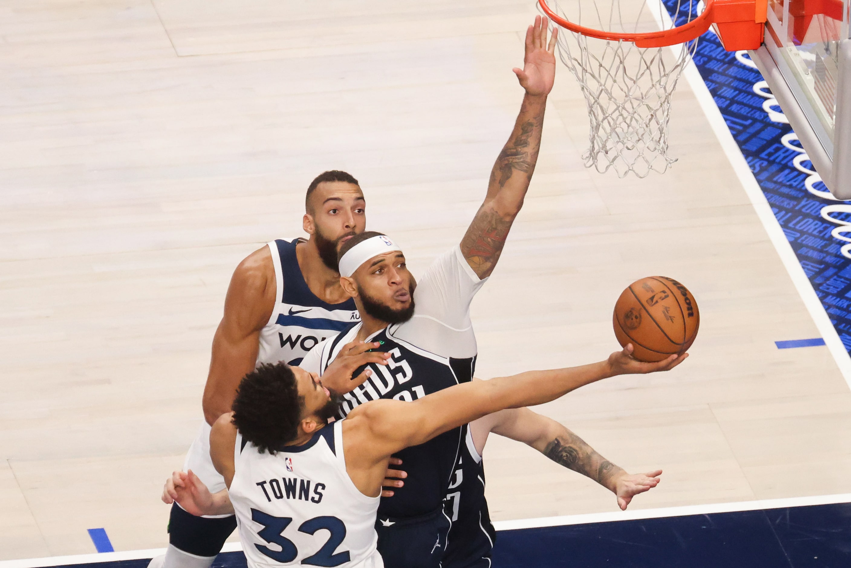 Dallas Mavericks center Daniel Gafford (center) blocks Minnesota Timberwolves center...