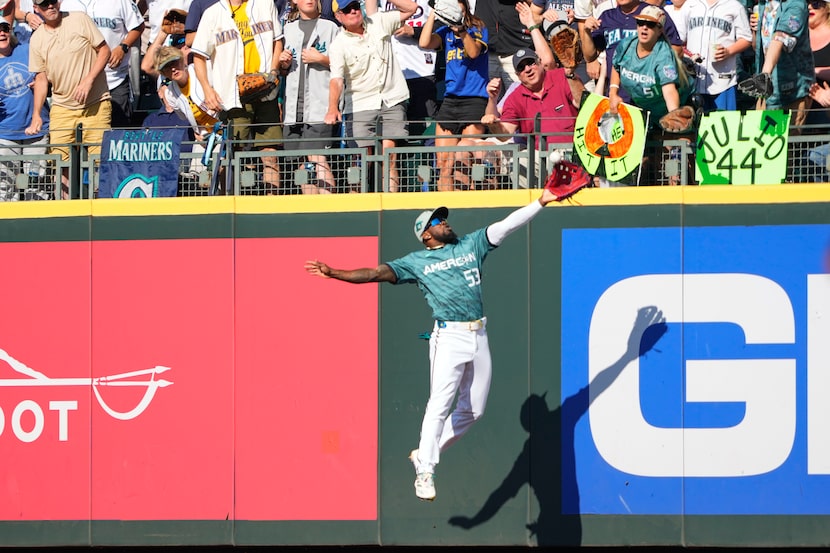 American League outfielder Adolis García, of the Texas Rangers, (53) grabs a fly ball by...