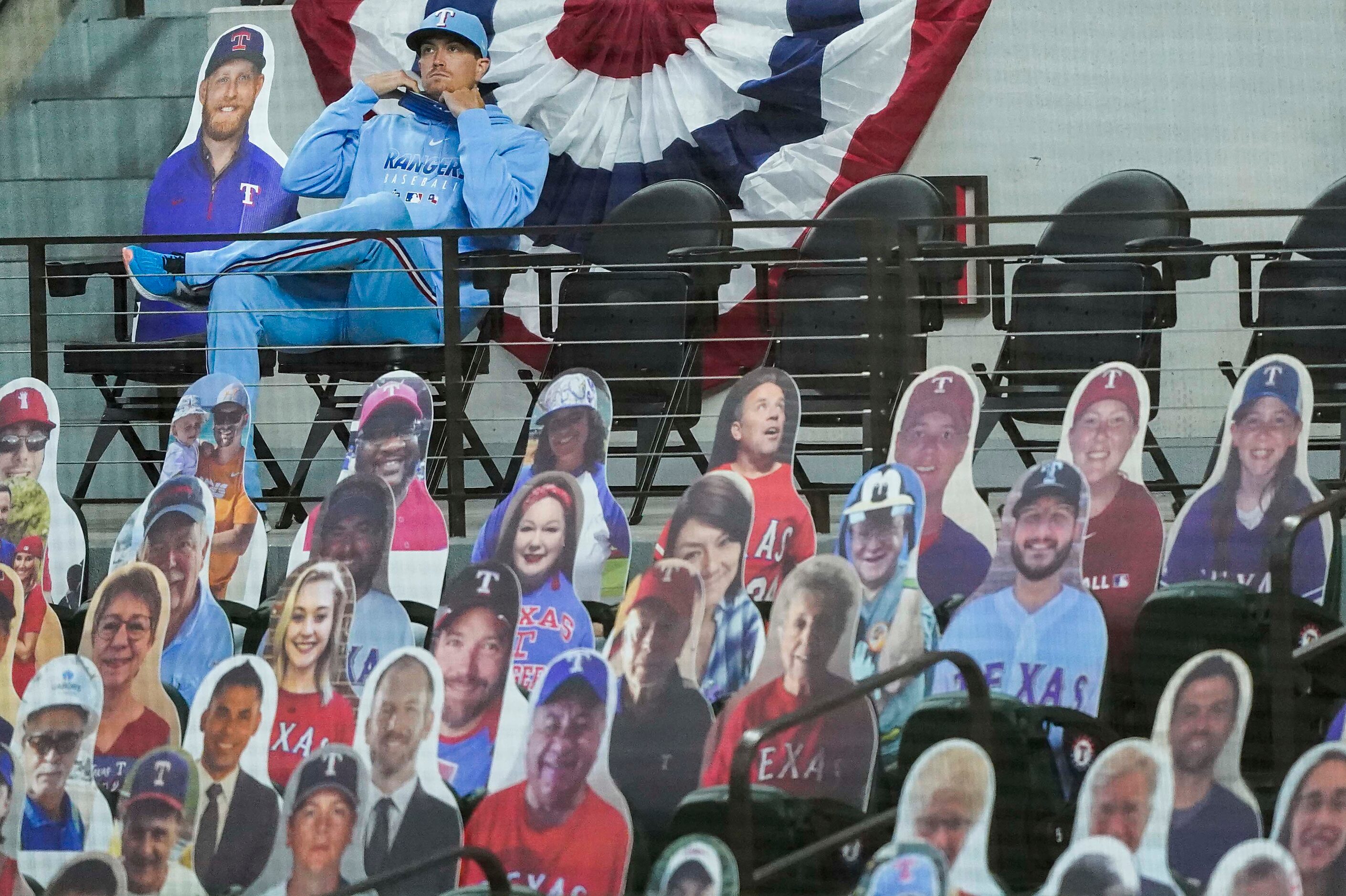 Texas Rangers pitcher Kyle Gibson adjusts his mask as he watches the Rangers face the...