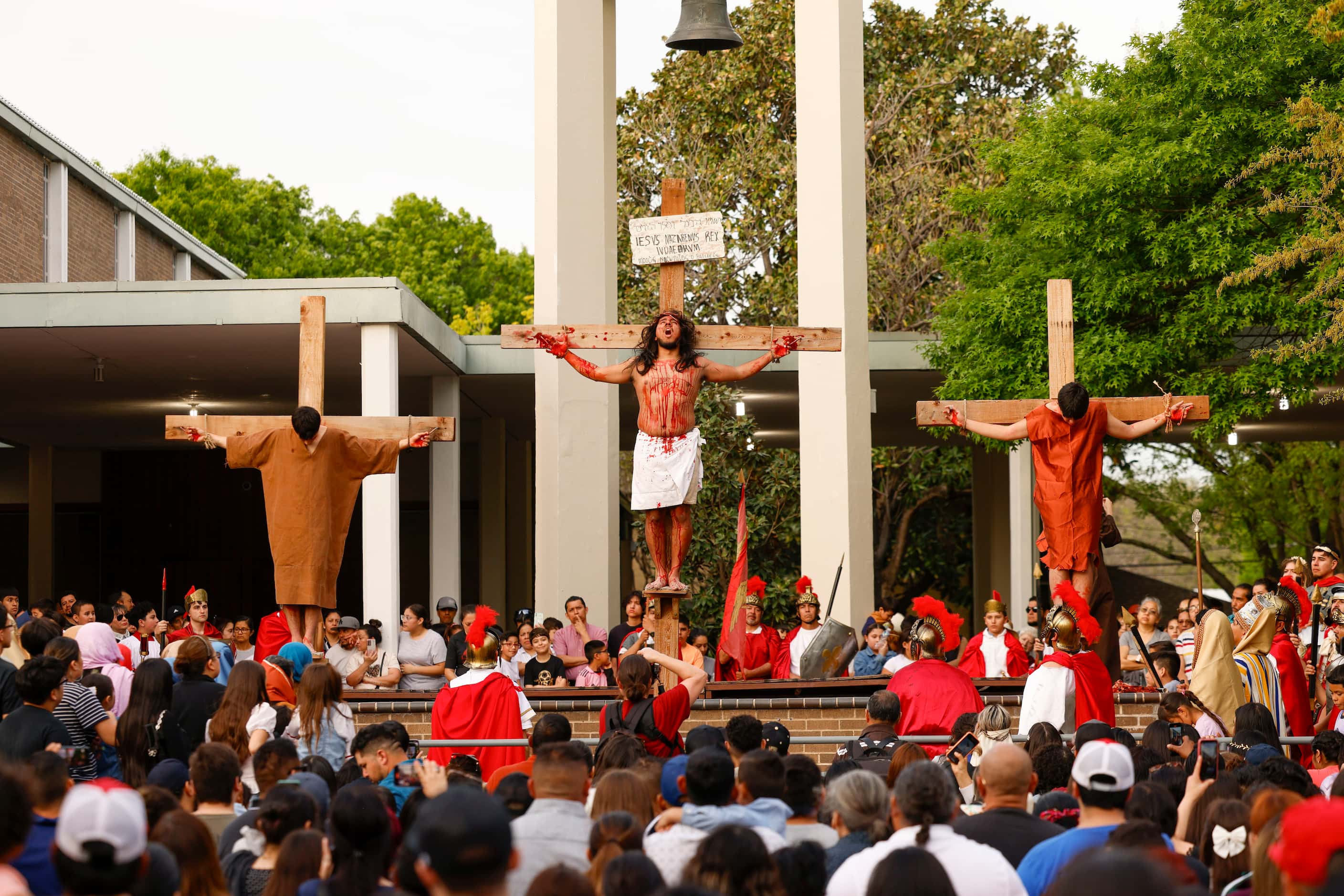 Crowd watch the Living Stations of the Cross crucifixion reenactment on Friday, March 29,...