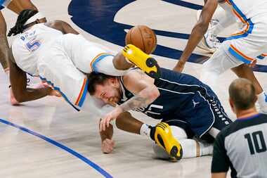 Dallas Mavericks guard Luka Doncic (77) tangles with Oklahoma City Thunder guard Luguentz...