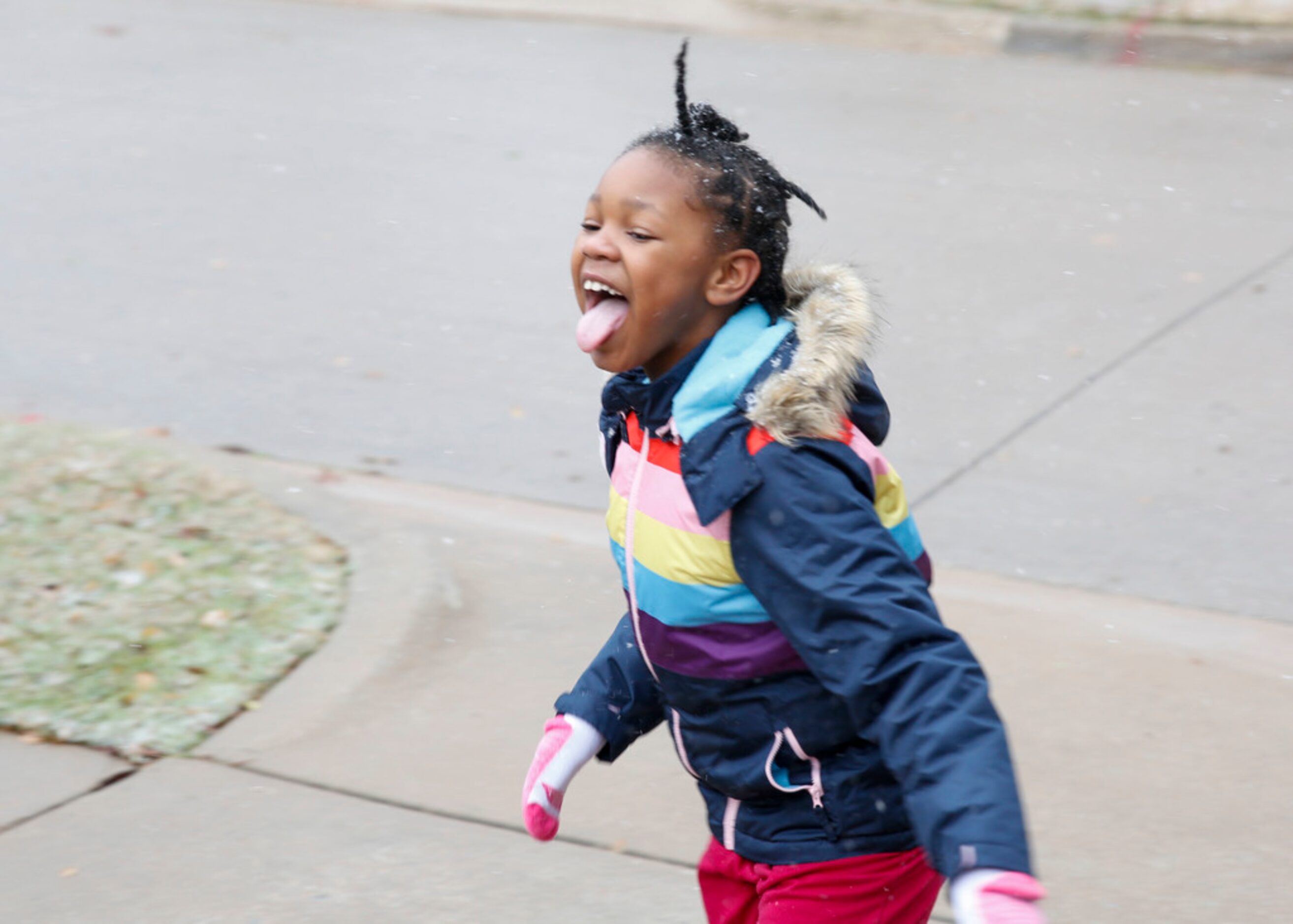 7-year-old Damyri Small tries to catch snow on her tongues as it snows in McKinney, Texas...