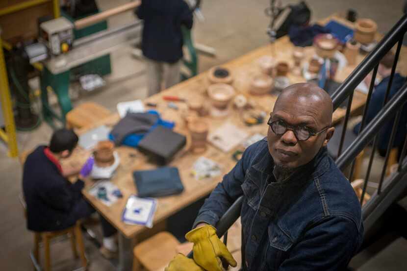 Sculptor Emmanuel Gillespie in the studio at The Winston School with his students who are...