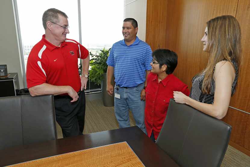 From left: Ed Heffernan meets with tax manager Domingo Pena, chief accounting officer Laura...