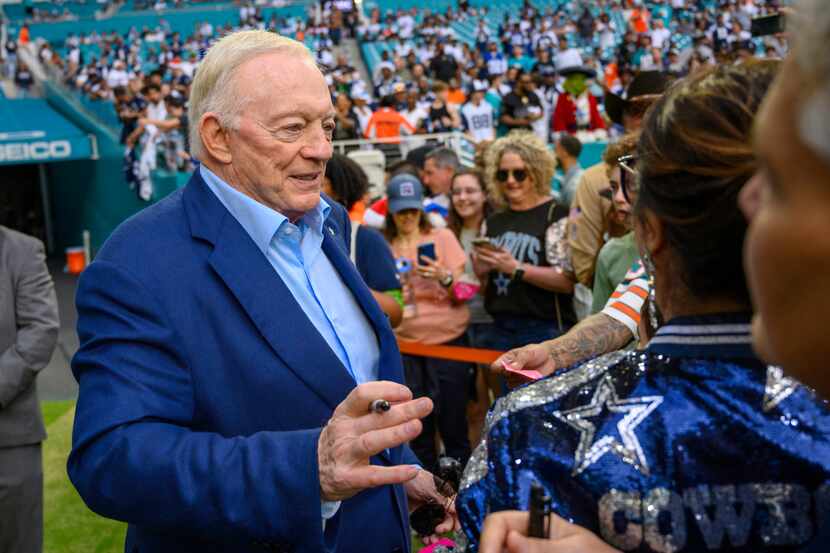 Dallas Cowboys owner Jerry Jones signs autographs for fans on the sidelines before an NFL...