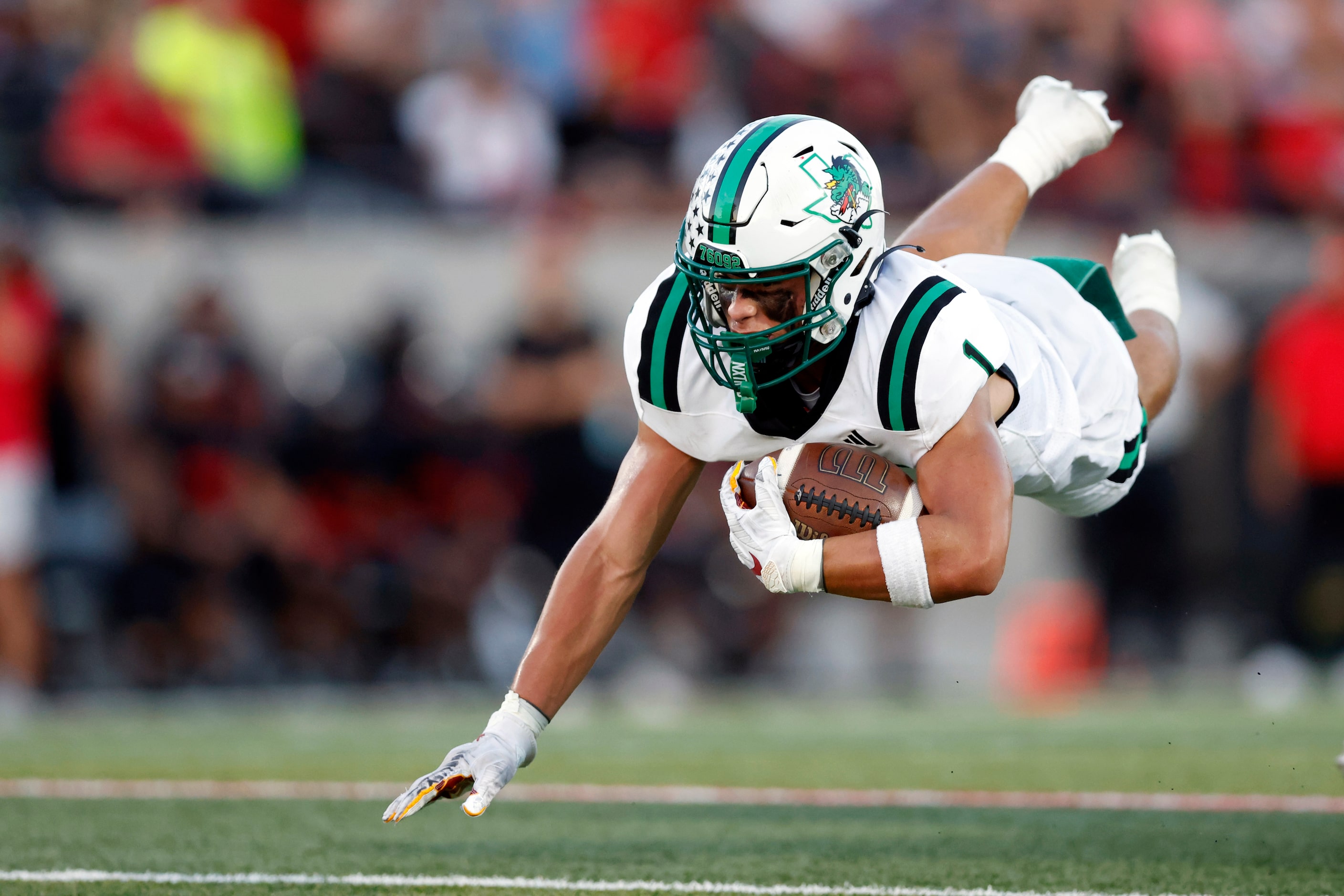 Southlake Carroll running back Riley Wormley (1) falls to the ground after being tripped at...