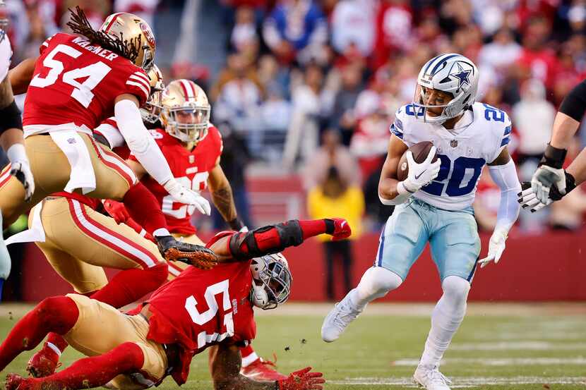 Dallas Cowboys running back Tony Pollard (20) is spun around by San Francisco 49ers...