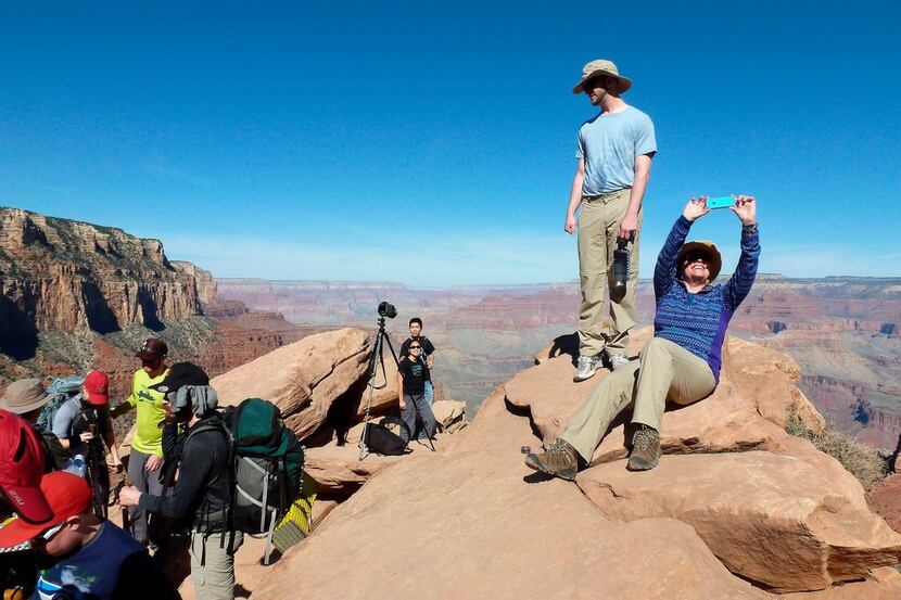 Hikers stop and take photos along the Grand Canyon National Park's South Kaibab trail. With...