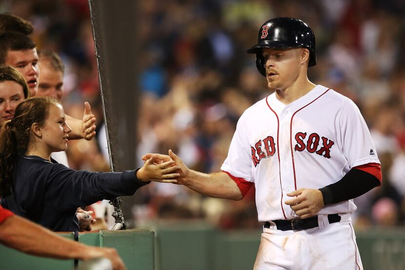 FILE - Brock Holt of the Red Sox high-fives teammates after scoring in the fourth inning of...