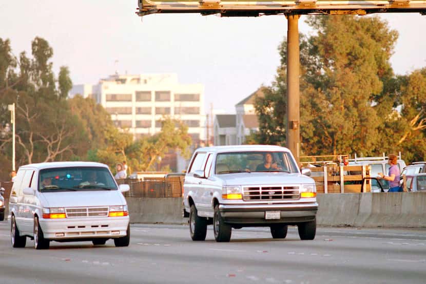 Al Cowlings, with O.J. Simpson hiding, drives a white Ford Bronco as they lead police on a...