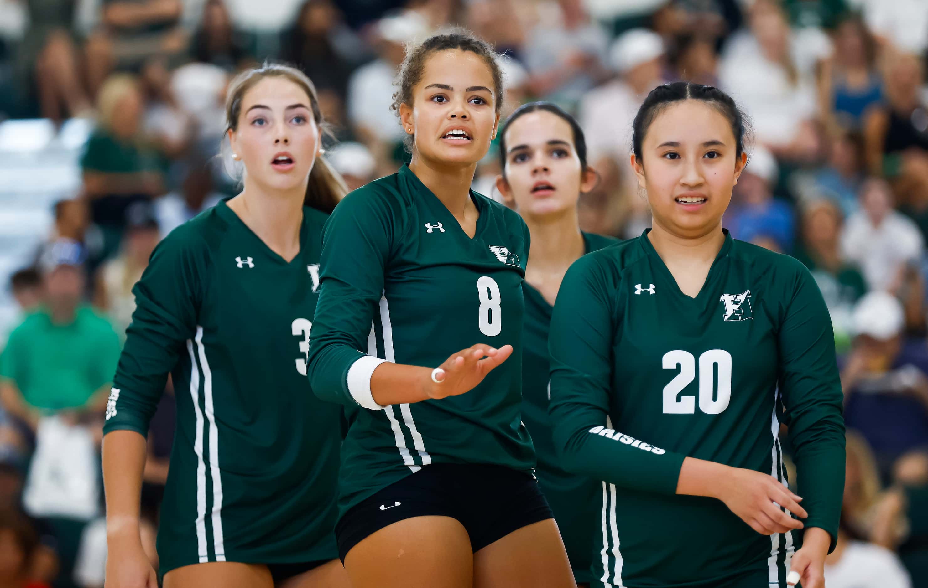 Hockaday senior outside hitter Avery Jackson, center, and her teammates look to their...