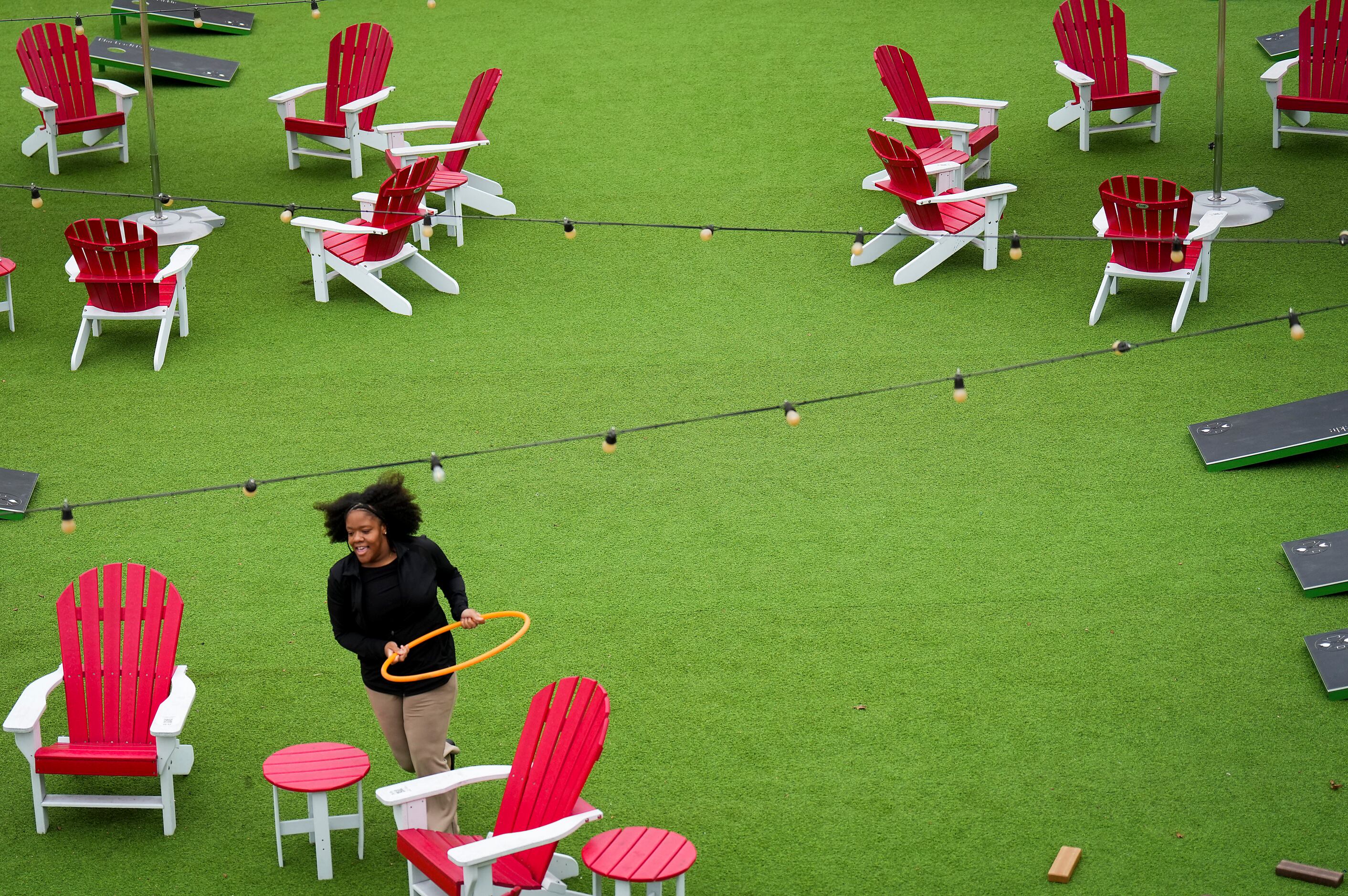 Patrons play with a hula hoop on the patio at Chicken N Pickle on Friday, Dec. 9, 2022, in...