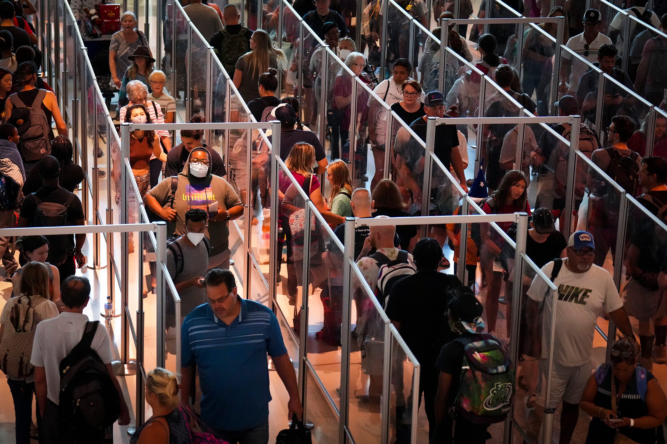 Passengers wait in a TSA security line after reentering Dallas Love Field Airport on Monday,...