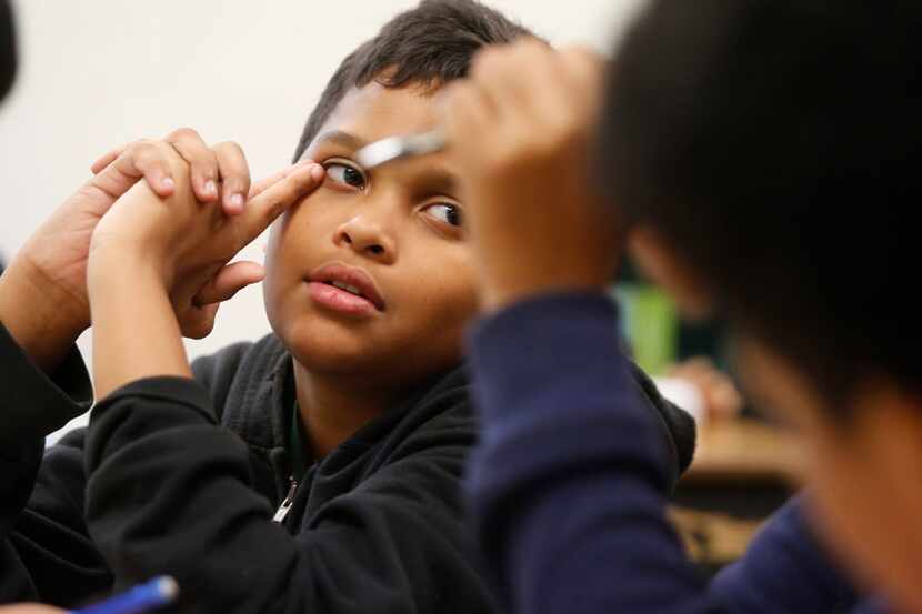 Then-seventh-grader Miles Goltl listened to a classmate as they worked on a city brochure...