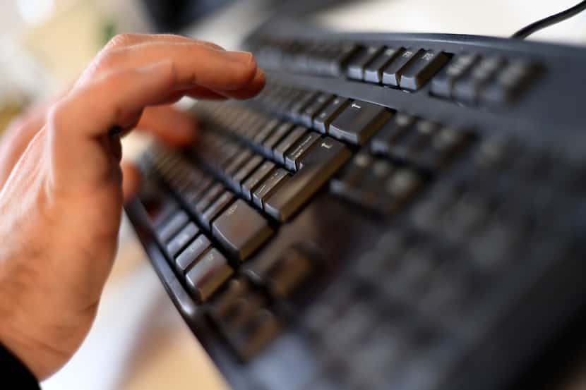 A file photo taken on October 17, 2016 shows an employee typing on a computer keyboard at...