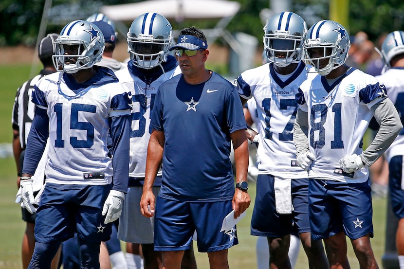 Dallas Cowboys wide receiver coach Sanjay Lal, center, is surrounded by his players Deonte...