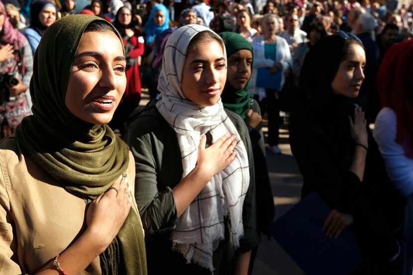 Hiba Loya and Donia Kased both of Houston as the national anthem is sung during a press...