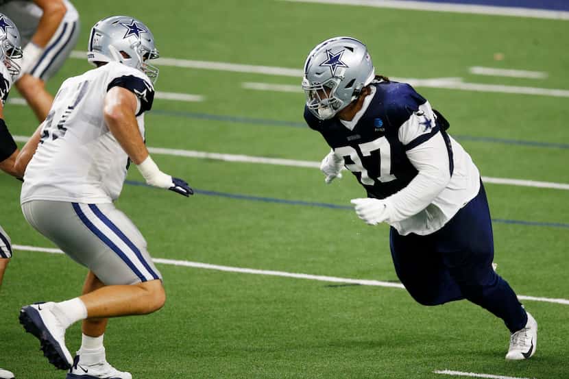 Cowboys defensive tackle Trysten Hill (97, right) rushes against offensive tackle Wyatt...