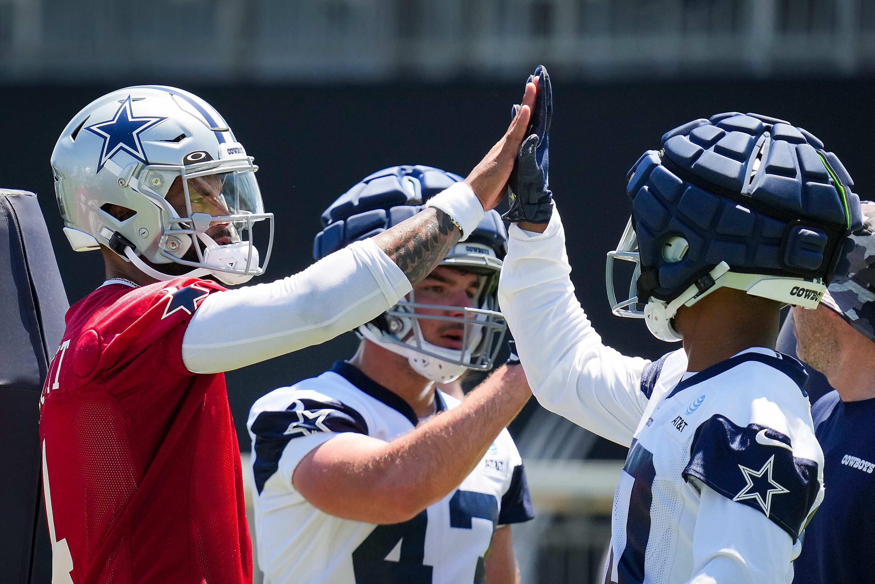 Dallas Cowboys quarterback Dak Prescott (4) high fives running back Tony Pollard (20) during...