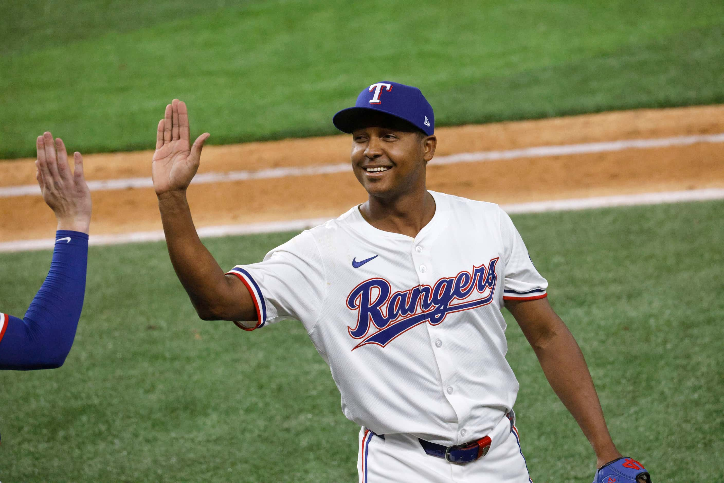 Texas Rangers pitcher José Leclerc (25) gets a high-five after the top of the eighth inning...