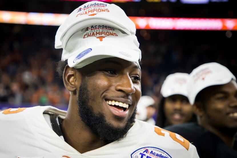 Texas defensive back Kris Boyd wears multiple championship hats as he celebrates after a win...