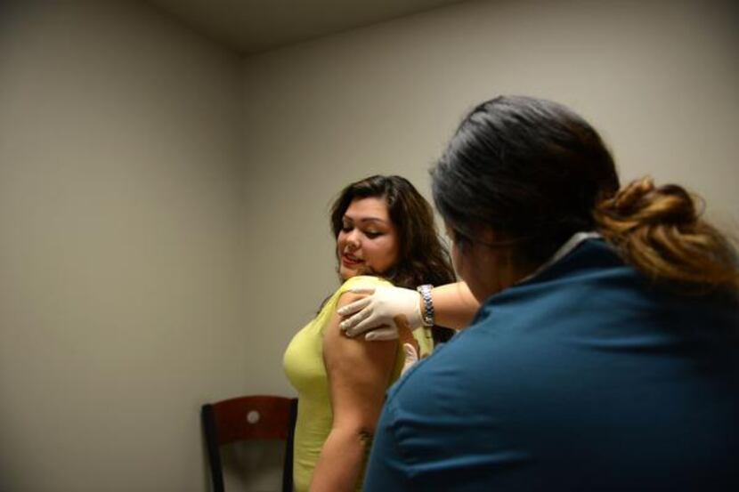 
Medical assistant Priscilla Lopez gives a flu shot to Stephanie Salas on Nov. 21 at Brother...