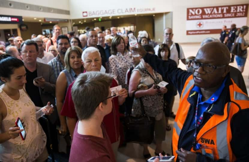  Southwest Airlines employee Darryl Thomas helps direct travelers through through the chaos...