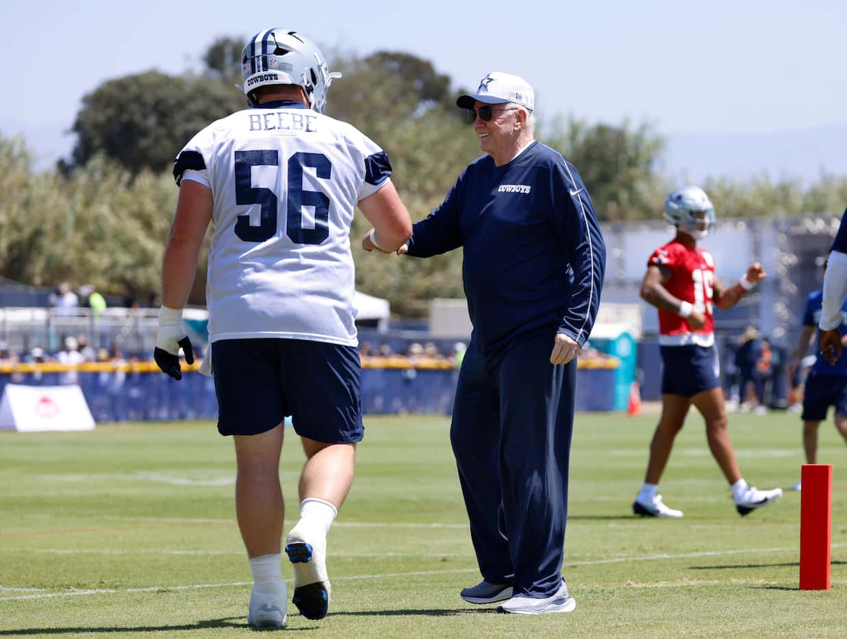 Dallas Cowboys owner Jerry Jones gives a fist bump to rookie center Cooper Beebe (56) as he...