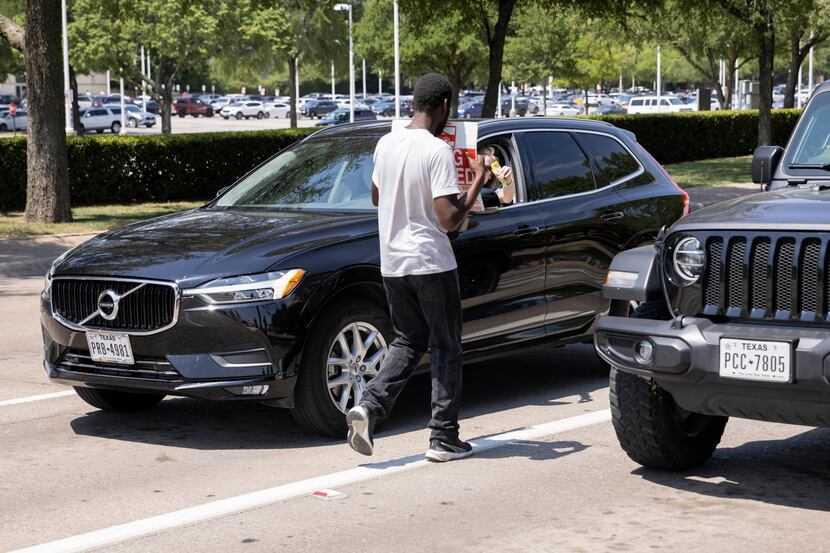A driver hands Alvin Jackson food at Park Lane and North Central Expressway on Tuesday, June...