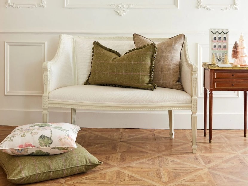 Plaid throw pillows on a white settee.