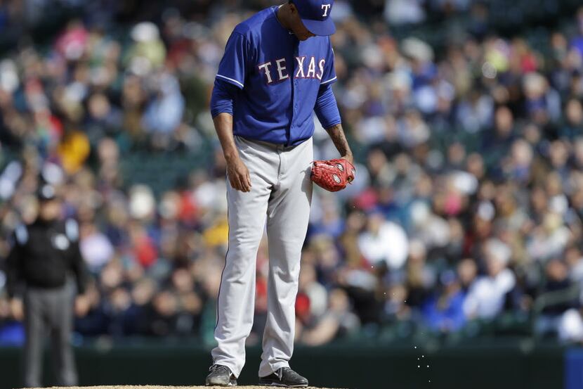 Texas Rangers relief pitcher Alexi Ogando stands on the mound after giving up a three-run...